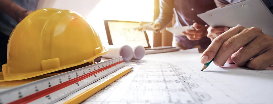charts and scales placed together A person with a hard hat on and some construction plans