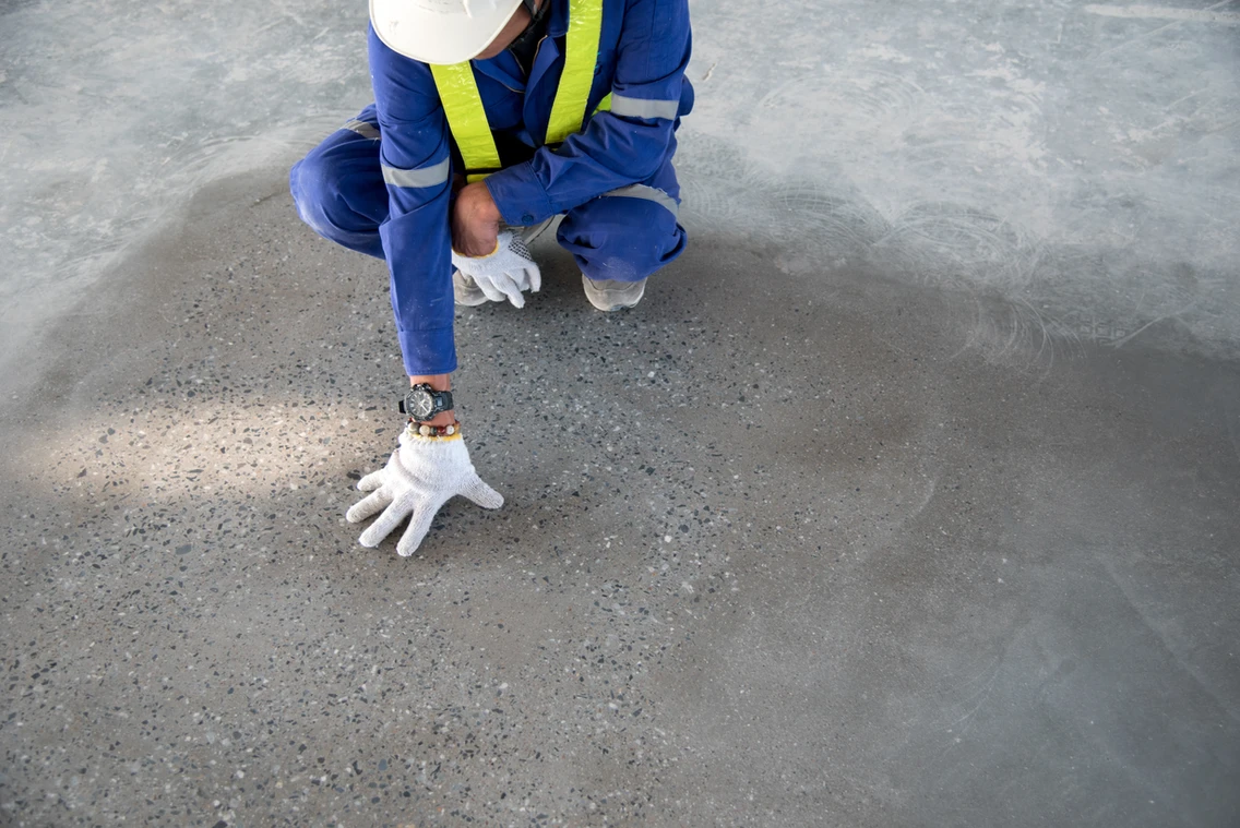 A person kneeling down on the ground with their hands in front of them.