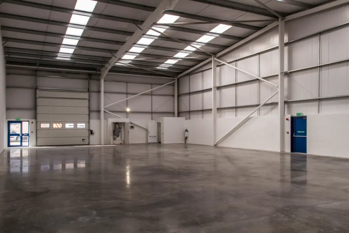 A large warehouse with many windows and lights.