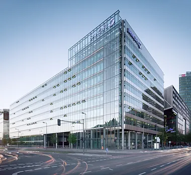 Outside view of a Office Building A large glass building with traffic lights on the side.