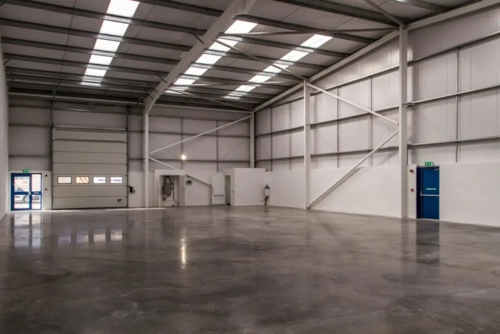 A large warehouse with lots of windows and lights.
