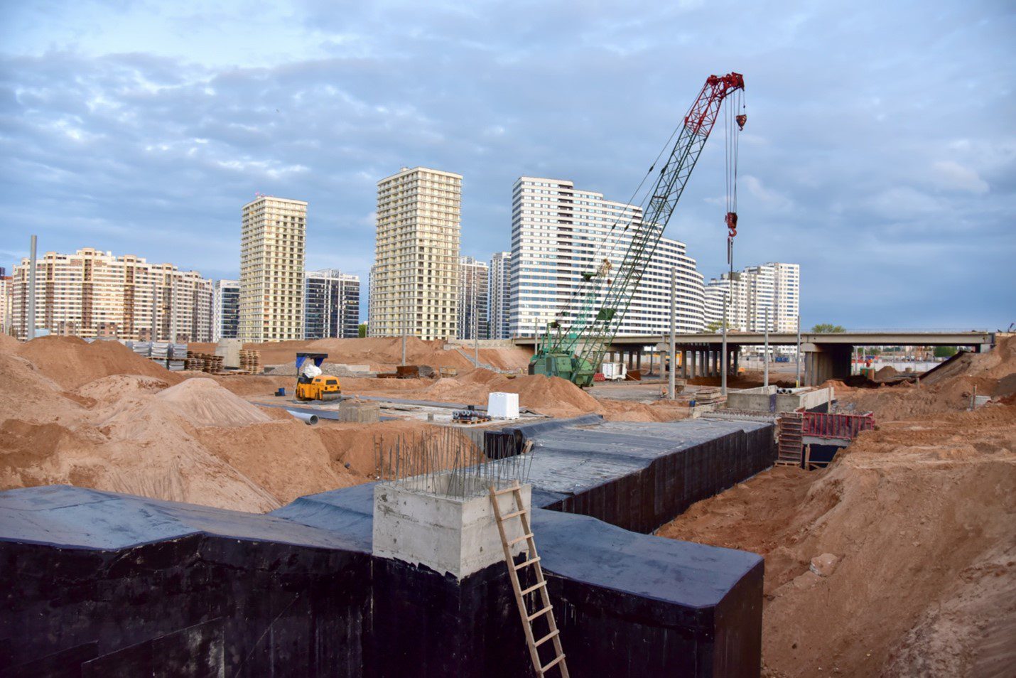 A construction site with many buildings and cranes.