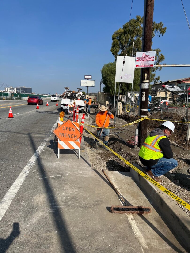 Roadside construction with open trench.