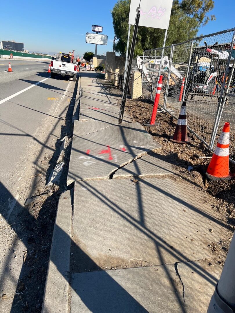 Cracked sidewalk near construction site.