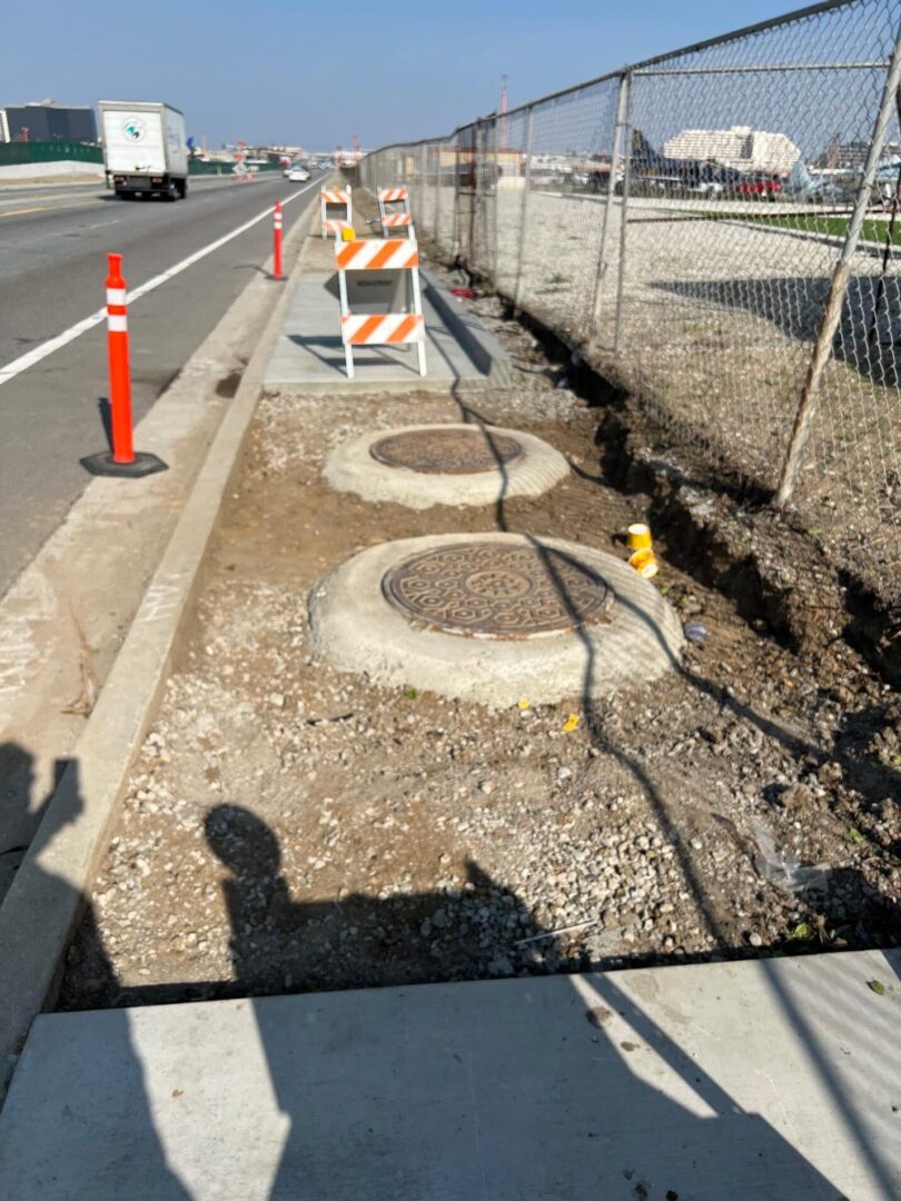 Roadside with three sewer grates.