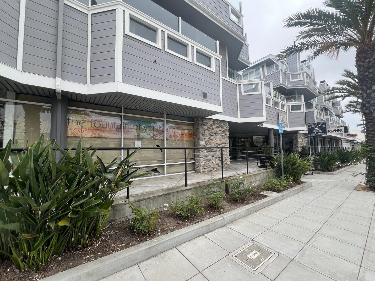 Exterior of a gray building with a sign.