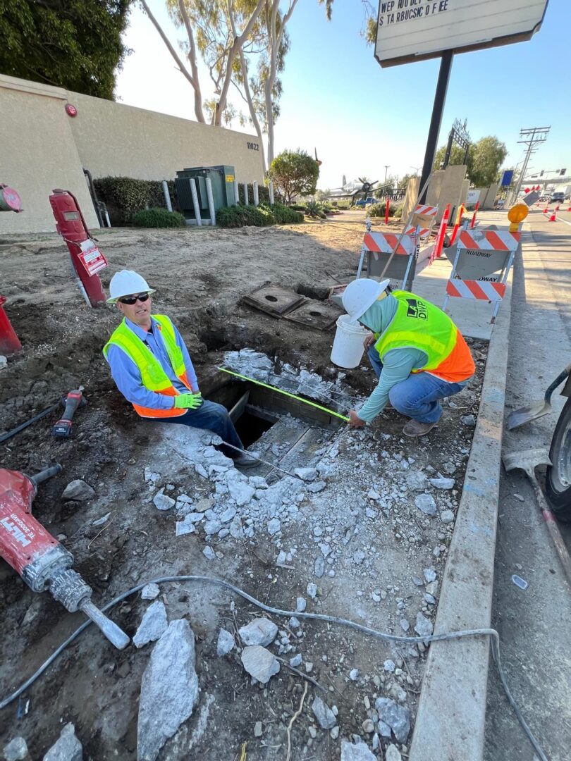 Two construction workers working on a road.