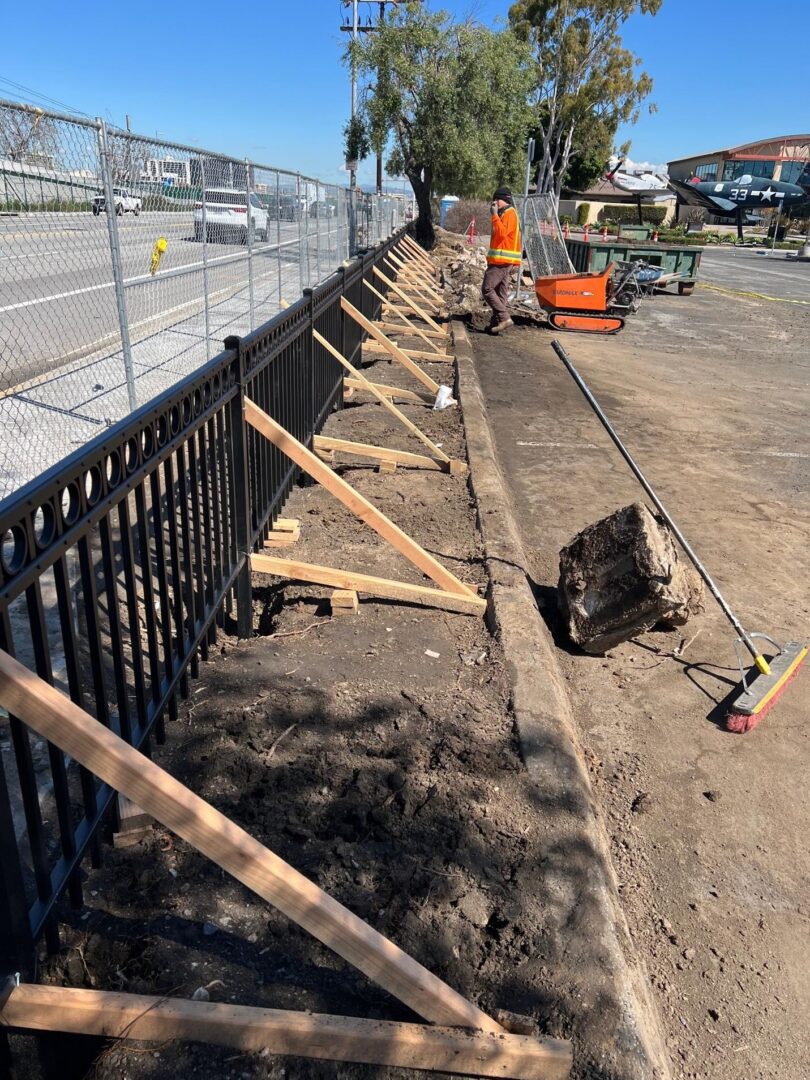 Black fence construction with wooden supports.