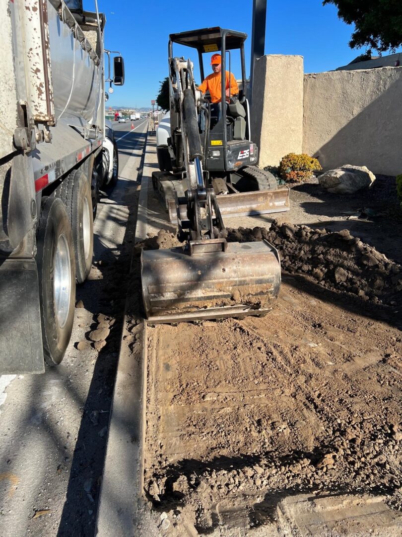 Excavator digging dirt near a truck.