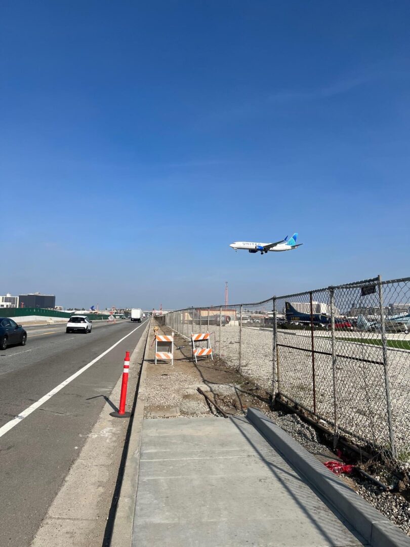 Airplane landing on runway near highway.